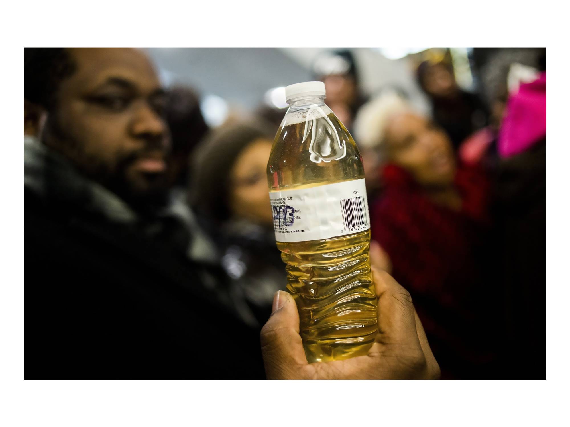 Person holding bottle of dirty water filled from the Flint River